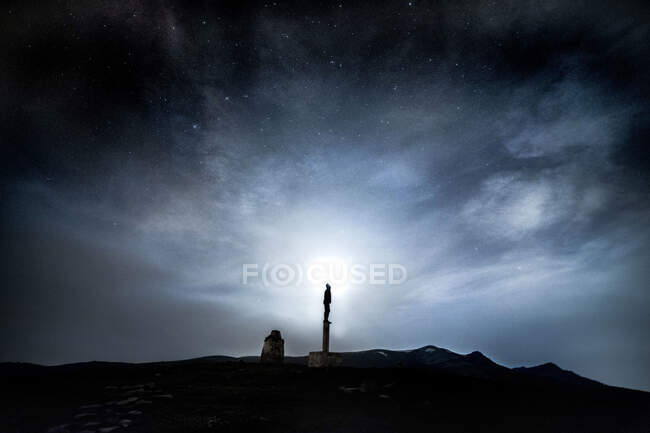 Silhouette of anonymous person standing in nature on background of magnificent night sky — Foto stock