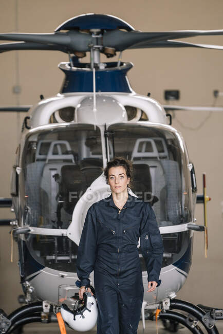 Pilot girl poses with her helicopter and helmet — Stock Photo