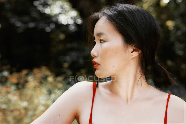 Joven asiática posando mirando lejos - foto de stock