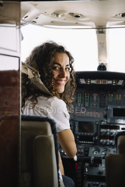 Brunette femme navigation avion et regarder la caméra — Photo de stock