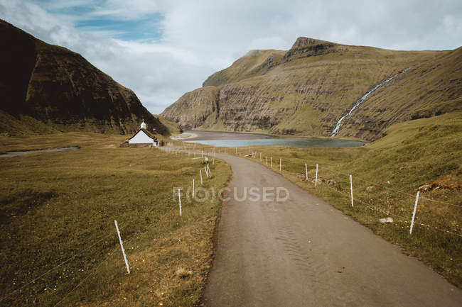 Veduta panoramica del piccolo sentiero verso il lago tra le scogliere delle isole Feroe — Foto stock