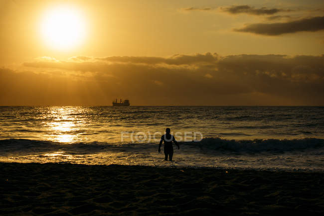 Vieil homme fort marchant sur la plage — Photo de stock