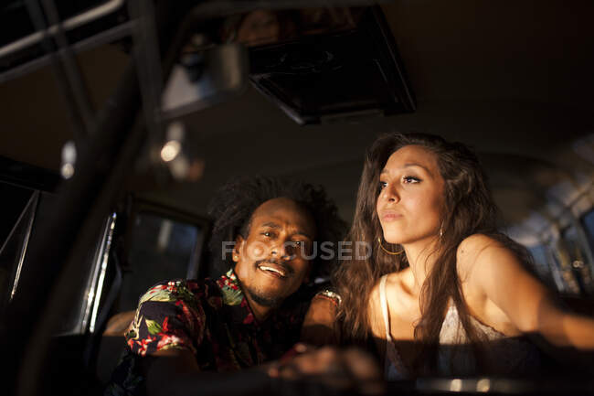 Красивая и молодая девушка брюнетка наслаждается поездкой в своем винтажном фургоне с друзьями — стоковое фото