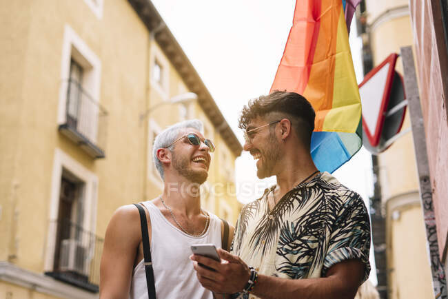 Gay casal de meninos com smatphone no o cidade de madri — Fotografia de Stock