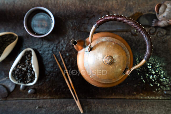 Von oben Teekanne und trockene Teeblätter auf orientalischem Tisch für traditionelle Zeremonie — Stockfoto
