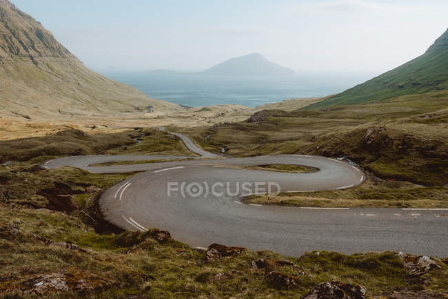Serpentina carretera en las montañas costeras, Islas Feroe - foto de stock