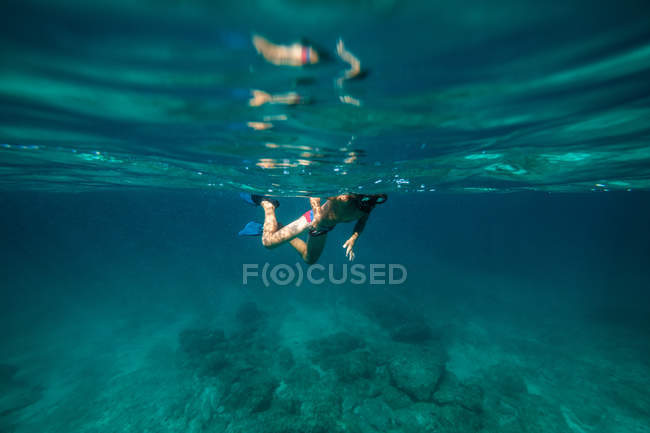 Garçon méconnaissable plongée avec tuba dans l'eau de mer sombre — Photo de stock