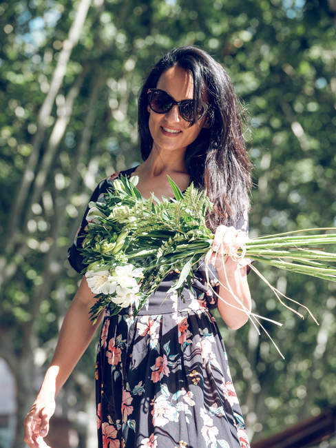 Приваблива жінка з купою квітів — стокове фото