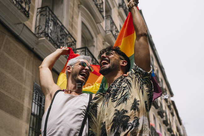 Пара хлопців з гей-прайд-прапором на вулиці Мадрида — стокове фото