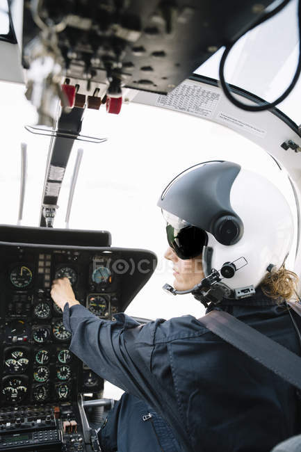 Focused female pilot sitting and operating in helicopter — Stock Photo