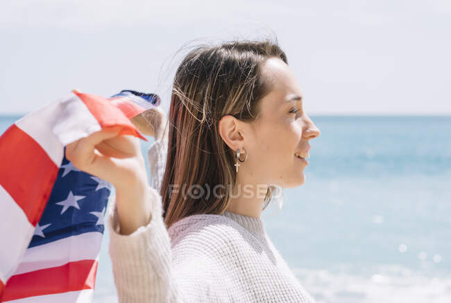 Дівчинка на пляжі з прапором США.. — стокове фото