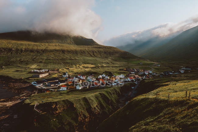 Vista da pequena aldeia em grandes montanhas verdes nas Ilhas Feroé — Fotografia de Stock