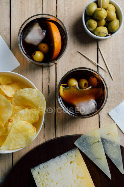 Cocktails and snacks served on wooden table — Stock Photo