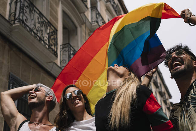 Grupo de amigos com uma bandeira de orgulho gay na cidade de Madrid — Fotografia de Stock