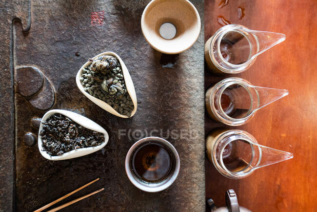 De arriba la tetera y las hojas secas de té sobre la mesa oriental para la ceremonia tradicional - foto de stock
