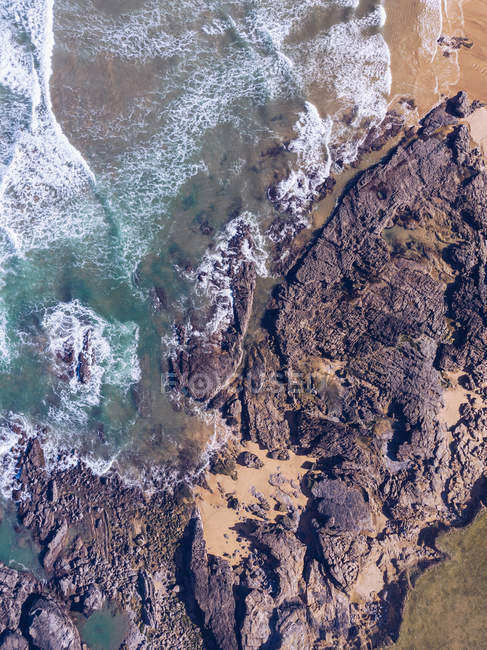 Atemberaubende Aussicht auf Meerwasser Spritzen in der Nähe lange felsige Klippe an bewölkten Tag in Asturien, Spanien — Stockfoto