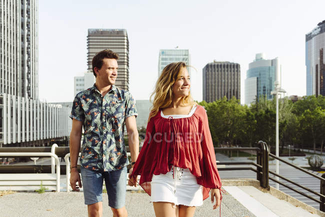Couple holding hands and walking on street — Stock Photo
