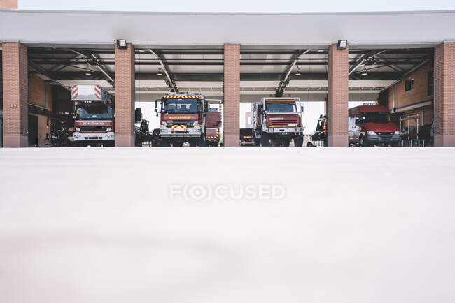Estación de bomberos con vehículos estacionados. - foto de stock