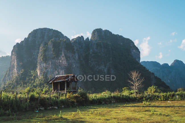 Невелика дерев'яна хатина і скелясті гори в природі — стокове фото