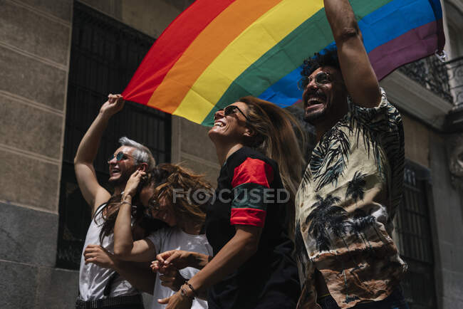 Gruppe von Freunden mit einer Flagge des Gay Pride in der Stadt Madrid — Stockfoto
