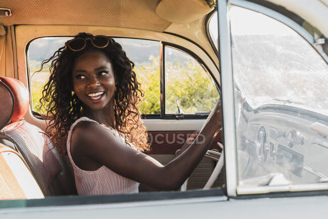 Красивая улыбающаяся африканская американка за рулем автомобиля — стоковое фото