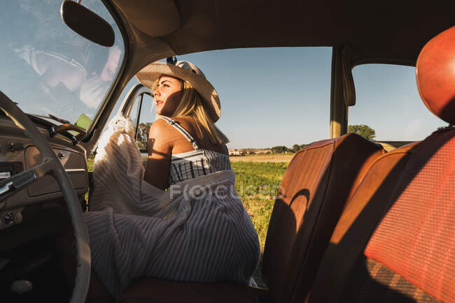 Жінка потрапляє в старовинну машину — стокове фото