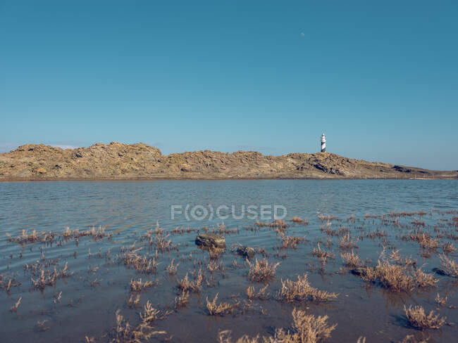 Blick auf das Leuchtturmgebäude auf einem kleinen Hügel an der Küste. — Stockfoto