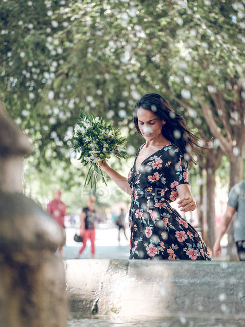 Приваблива жінка з купою квітів — стокове фото