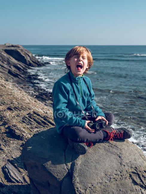 Fröhlicher Junge mit Fernglas am Meer — Stockfoto