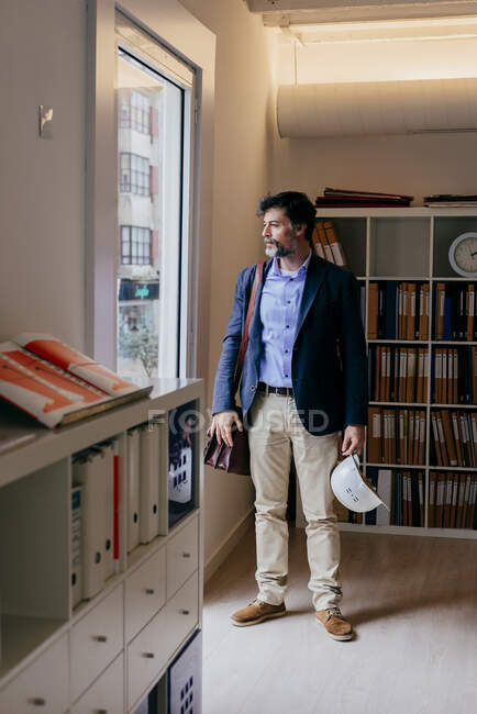 Jovem bonito olhando para longe no escritório — Fotografia de Stock