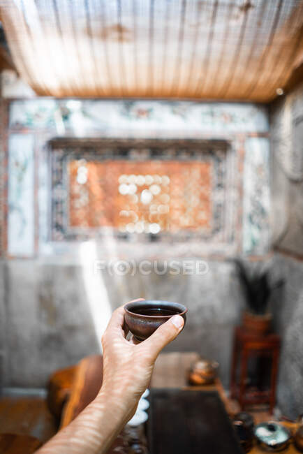 Crop hand of unrecognizable person holding cup of traditional oriental tea — Stock Photo