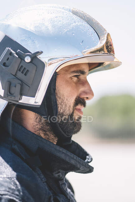 Bombeiro posa com capacete olhando para a câmera. — Fotografia de Stock