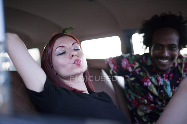 Schöne und junge Frau genießt die Fahrt in ihrem Oldtimer-Van mit ein paar Freunden — Stockfoto