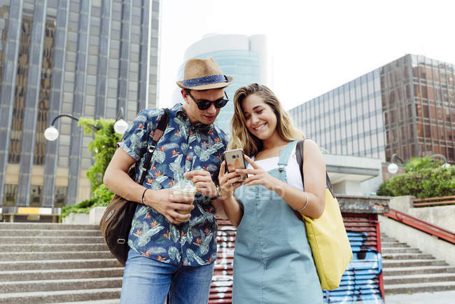 Couple browsing smartphone on street — Stock Photo