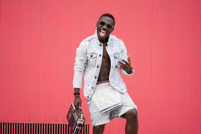 Африканский американец танцует с винтажным радиоприбором на красном фоне — стоковое фото