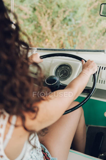 Mulher irreconhecível sentada no assento do motorista do carro vintage e dirigindo na natureza — Fotografia de Stock