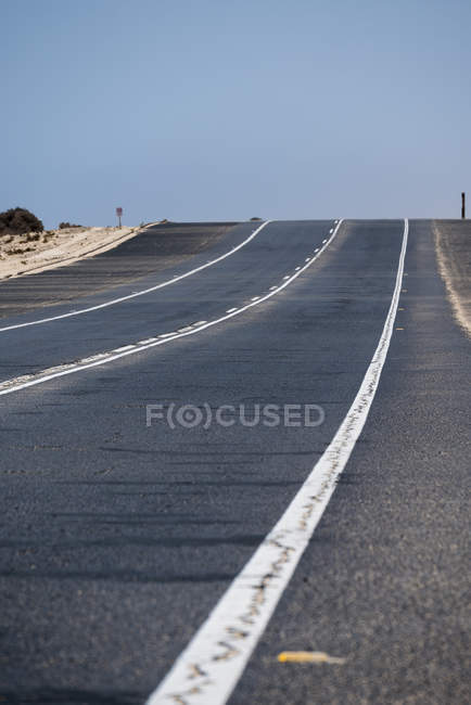 Estrada que atravessa o deserto árido de Fuerteventura, Ilhas Canárias — Fotografia de Stock