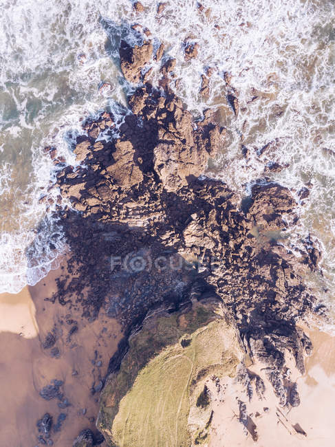 Amazing view of sea water splashing near long rocky cliff on cloudy day in Asturias, Spain — Stock Photo