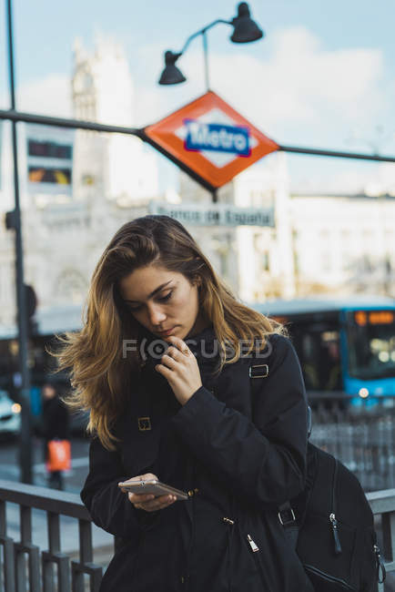 Mulher usando smartphone perto do subsolo na cidade — Fotografia de Stock