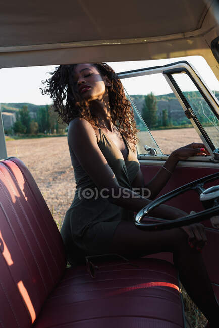 Fröhliche schwarze Frau schaut weg und sitzt in einem Oldtimer-Lieferwagen — Stockfoto