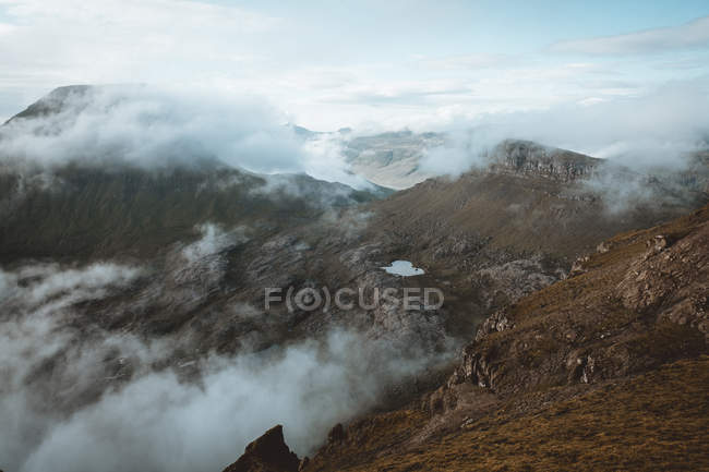 Montagnes rocheuses dans les nuages sur les îles Feroe — Photo de stock
