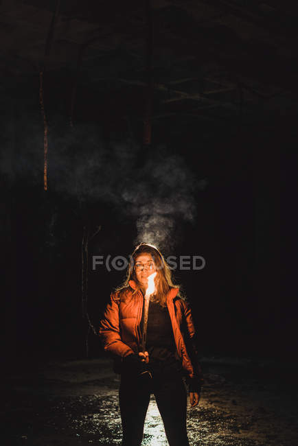 Mujer con antorcha de iluminación en la noche - foto de stock