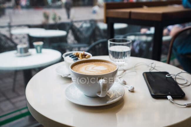 Чашка кави з мобільним телефоном — стокове фото