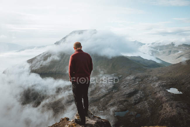 Турист стоит на краю горы и смотрит на вид на острова Фероэ — стоковое фото