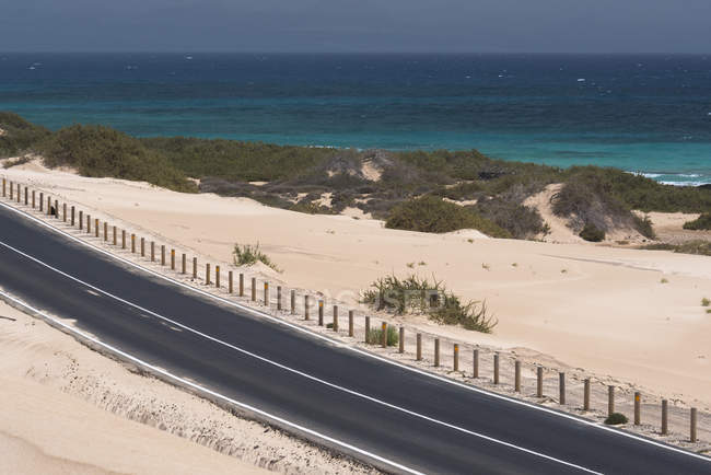 Road through desert and ocean water on Canary islands — Stock Photo