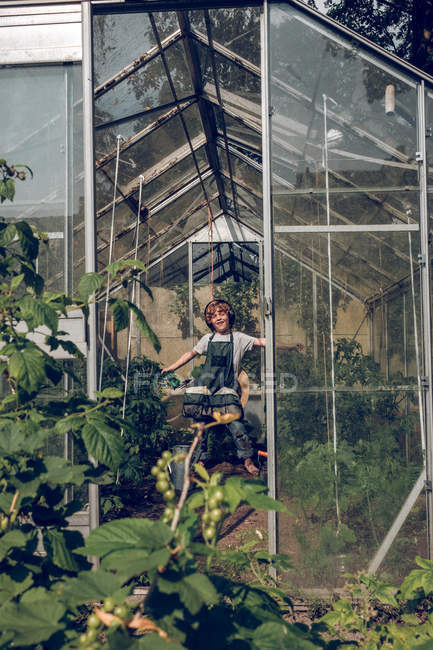 Boy listening to music in greenhouse — Stock Photo