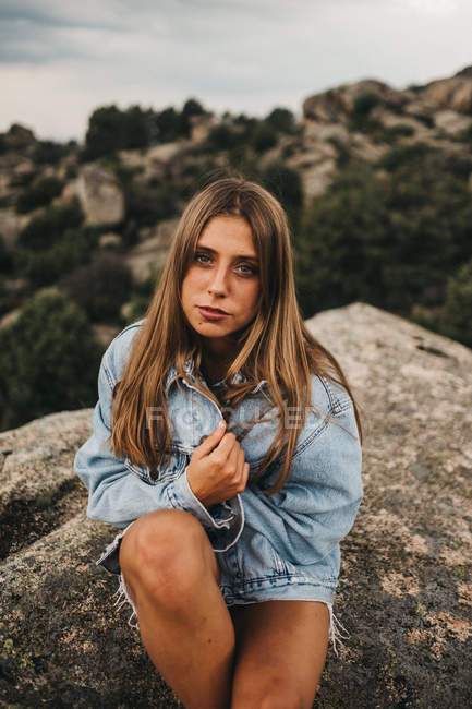 Donna in reggiseno seduta sulle rocce — Foto stock