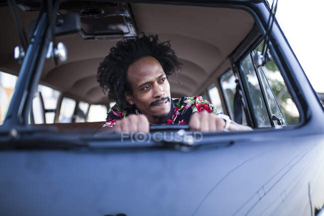 Bonito afro homem goza a viagem em seu vintage van com alguns amigos — Fotografia de Stock