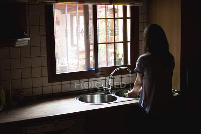 Donna che lava l'insalata in lavandino — Foto stock