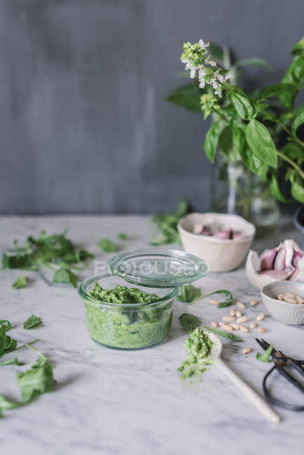 Handmade arugula pesto sauce in bowl on white marble counter — Stock Photo